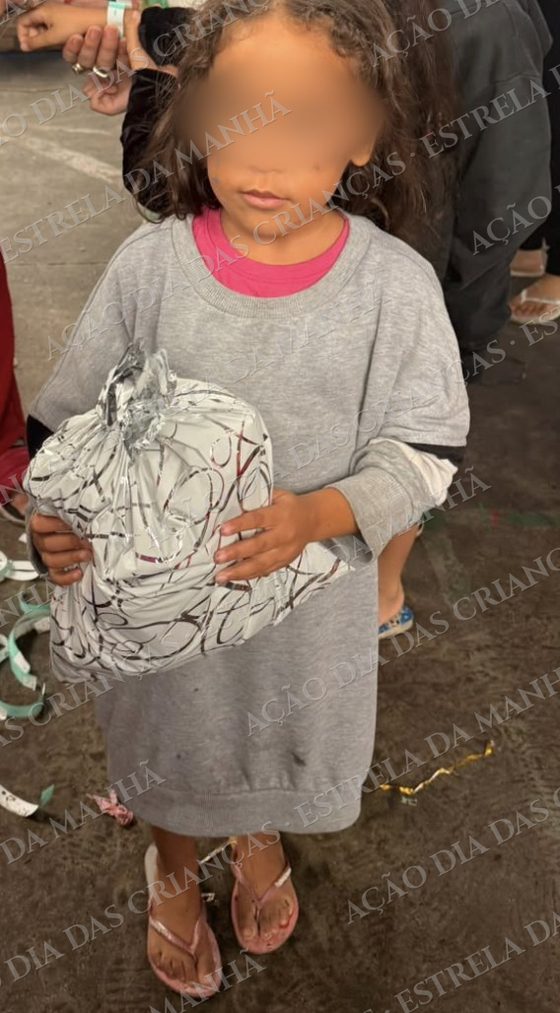 Criança sorri com seu presente no Dia das Crianças