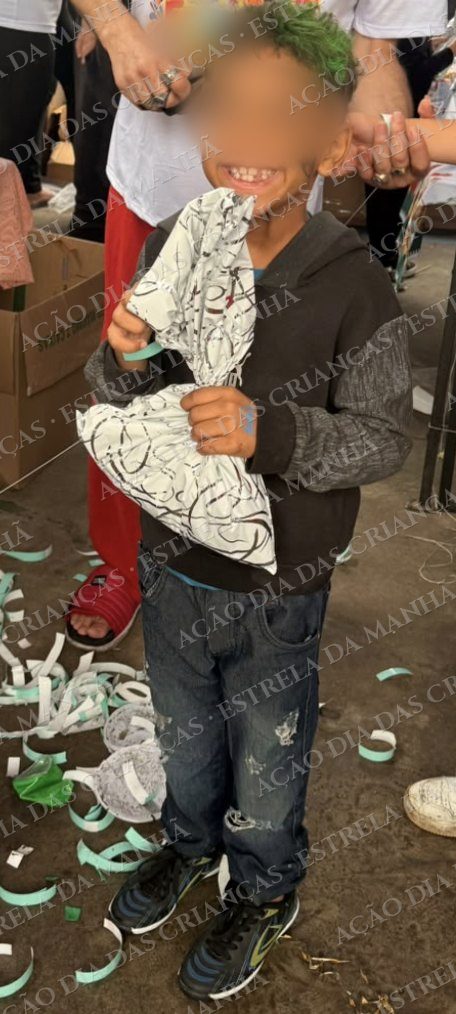 Criança sorri com seu presente no Dia das Crianças