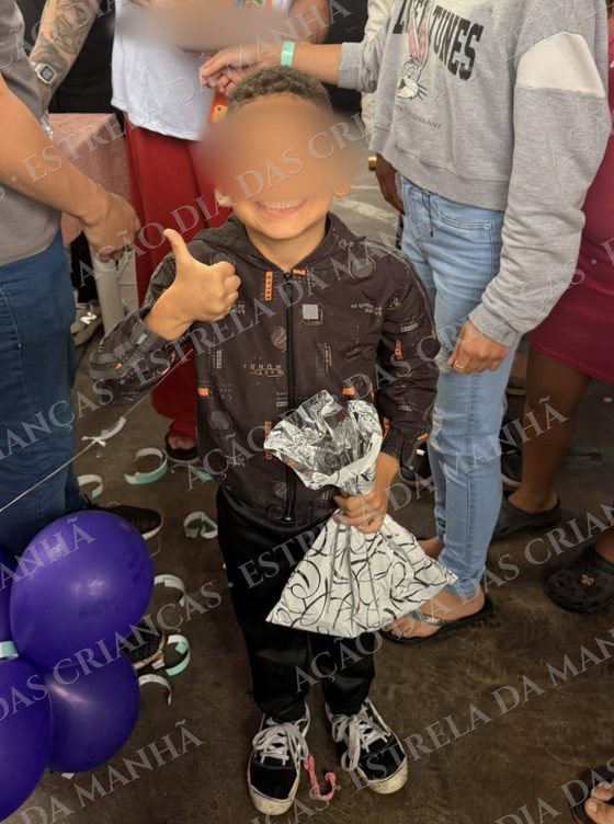 Criança sorri com seu presente no Dia das Crianças