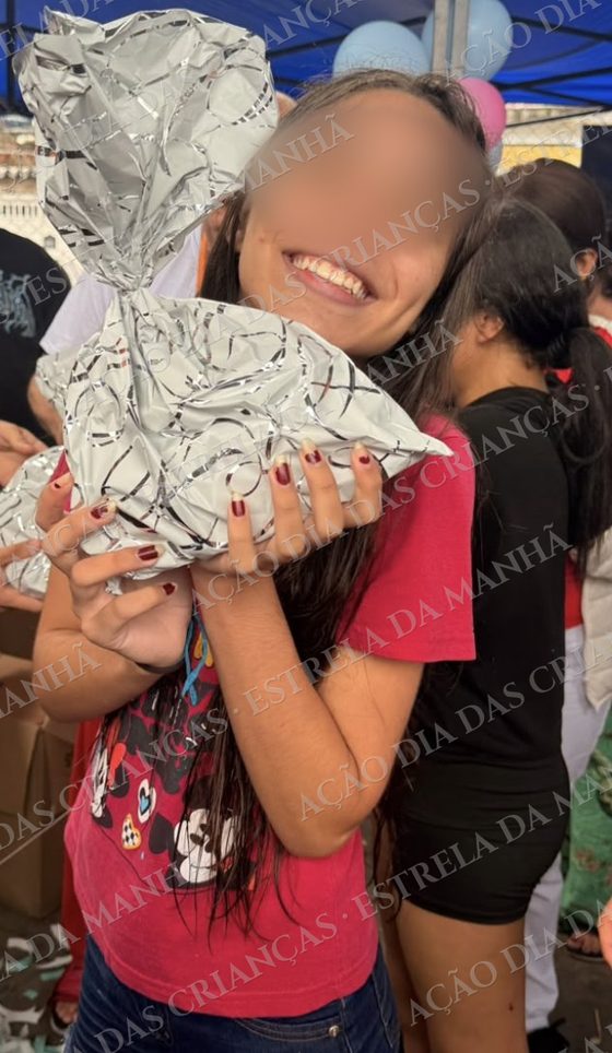 Criança sorri com seu presente no Dia das Crianças