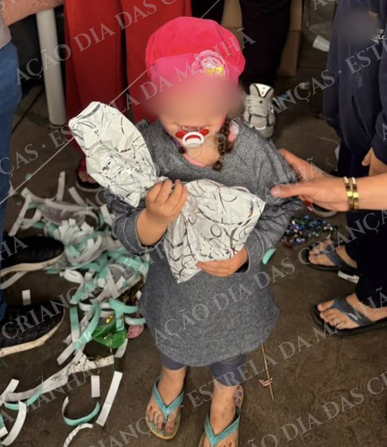 Criança sorri com seu presente no Dia das Crianças