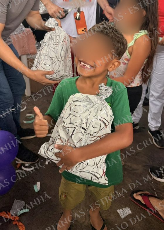 Criança sorri com seu presente no Dia das Crianças