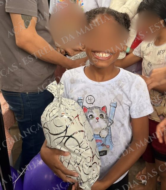 Criança sorri com seu presente no Dia das Crianças